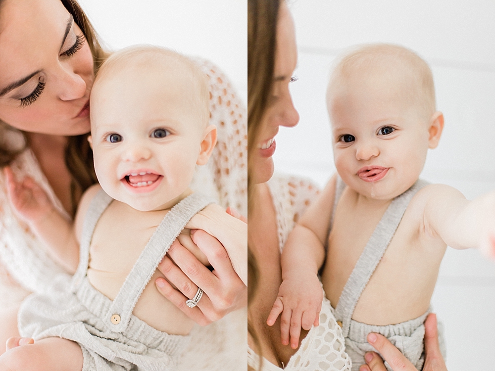 mom in white dress kissing baby on head while he's smiling in natural light studio by Tampa newborn photographer marisa stone photography